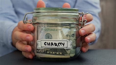 Unrecognizable woman put on table Glass jar full of American currency ...