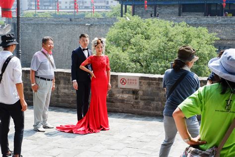 西安古城墙上年轻人拍写真 外国游客上前求合影