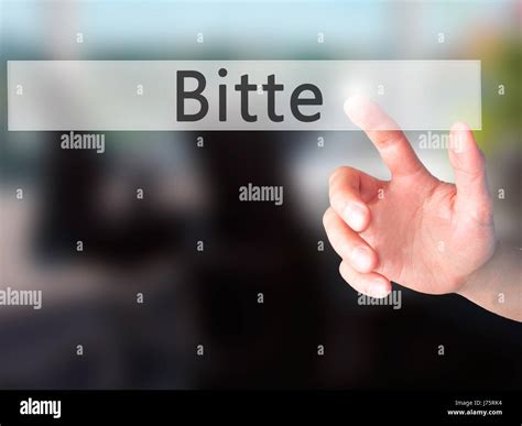 Bitte (Please in German) - Hand pressing a button on blurred background ...