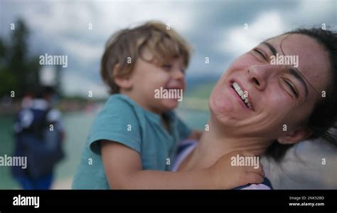 Funny mother and son moment. Little boy kissing mom in cheek pretending ...