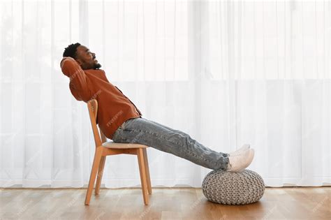 Premium Photo | Relaxed African American Man Sitting In Chair At Home
