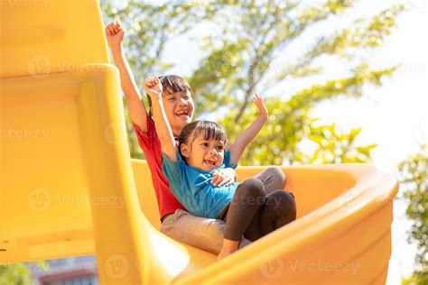 Cute little girls siblings having fun on playground outdoors on sunny summer day. Children on ...