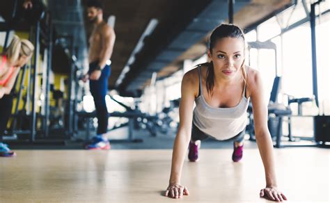 Healthy focused girl doing push ups - Hybrid Fitness