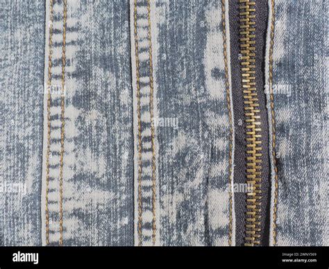 Close-up denim with seams and locks. Heavily shabby worn jeans. Metal ...