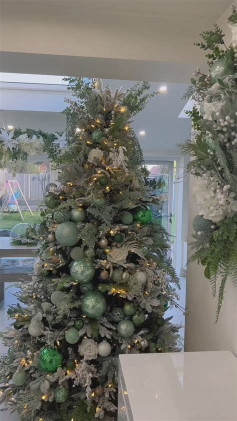 a Christmas tree decorated with green and gold glitter ornaments and ...