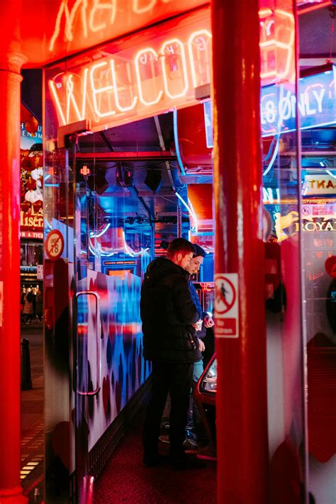 Man and woman standing under welcome signage at night photo - Free ...