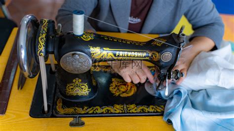 缝纫手工绗缝在车间的一个裁缝女人在白色的背景上-裁缝的手收集从桌面的彩色织物碎片在缝纫机上拼接照片摄影图片_ID:167792223-Veer图库