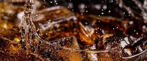 Pouring of cola and ice cola soda and ice splashing fizzing or floating ...