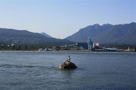 A statue of a woman is on a rock in the water | Premium Photo