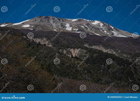 Mountain with Signs of Snow on the Peak and Dense Forest Around the ...