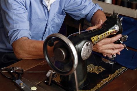 在家使用旧式缝纫机的年轻女裁缝配戴高清图片下载-正版图片504453667-摄图网