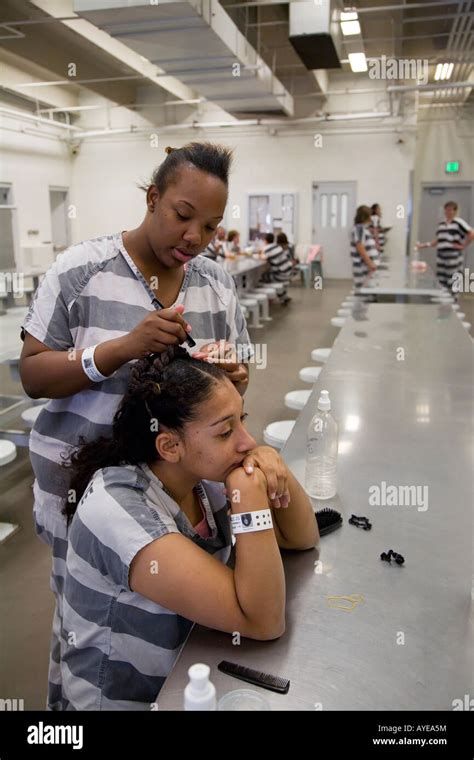 One female inmate works on another s hair in an indoor room at the ...