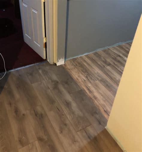 Installed two different color laminate flooring to define space between ...