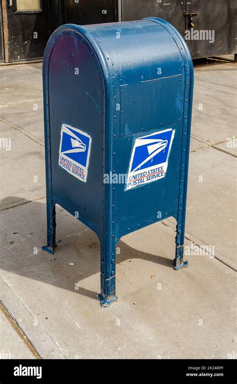 Blue United States Postal Service Mailbox standing on a sidewalk in ...