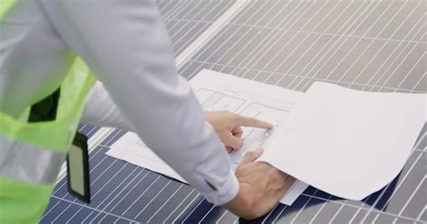 Engineer open blueprint of solar farm project on solar cells panel ...
