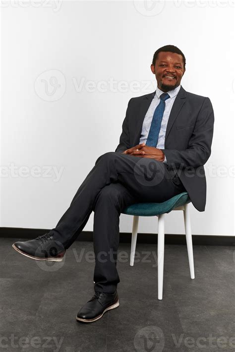 Smiling african american black man in business suit sitting on chair ...