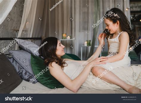 Mother and daughter cuddling on a bed in a kids room