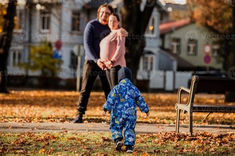 en un soleado otoño día en el parque, un madre y padre cariñosamente ...