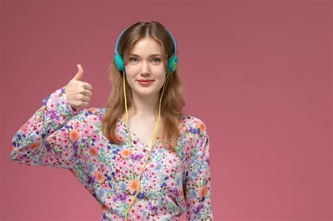 Mulher jovem de frente para cima com os polegares para cima e ouvindo ...