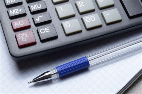 A ballpoint pen and a micro calculator lie on a squared notebook ...