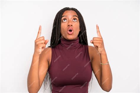 Premium Photo | Feeling awed and open mouthed pointing upwards with a ...