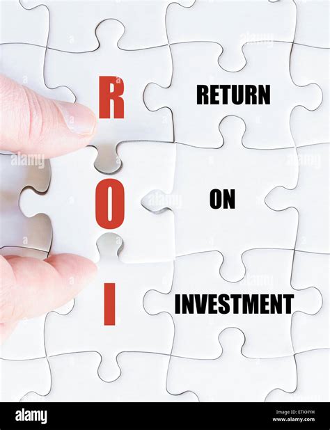 Hand of a business man completing the puzzle with the last missing piece.Concept image of ...