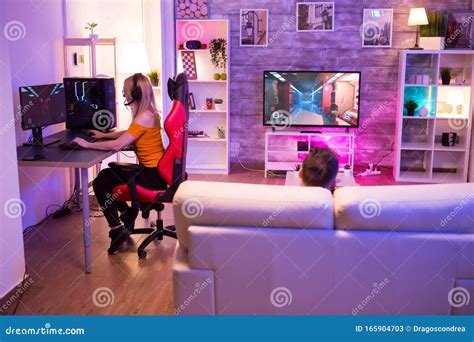 Blond Girl Playing Shooters Games in a Room with Neon Light Stock Image ...