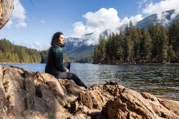 Adventurous caucasian woman on the rocks by the water in canadian ...