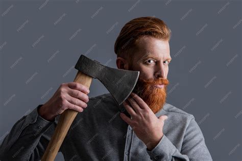 Premium Photo | Studio shot of red beard barber man holding axe blade ...