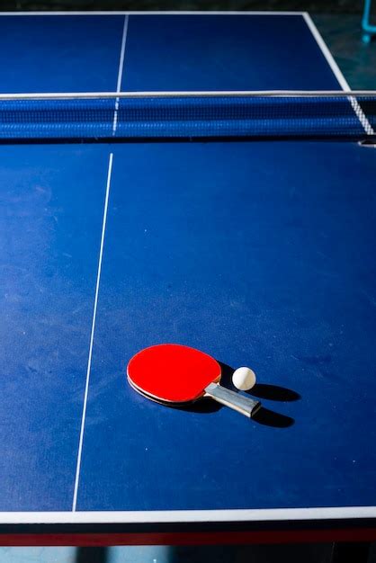 Table tennis racket on the blue ping pong table | Premium Photo