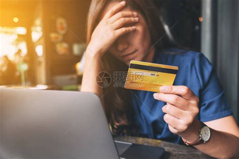 一个亚裔女在持有信用卡时紧张和破碎高清图片下载-正版图片504557469-摄图网