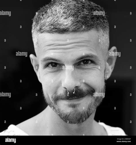 Grayscale portrait of an adult Spanish man with a septum piercing ...