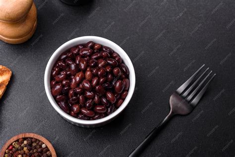 Premium Photo | Black canned beans in a white saucer against a dark ...