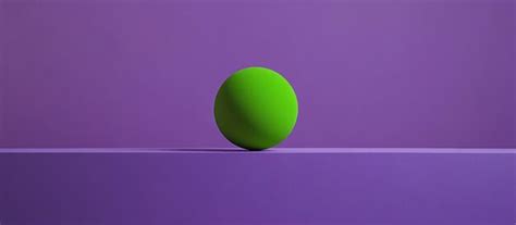 A green tennis ball on a purple surface with a purple background ...