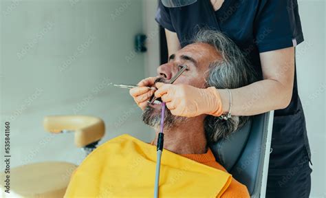 Dentist carrying out dental procedure on male patient, close-up