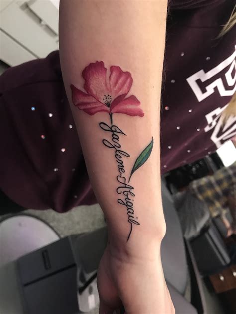 Wrist rose tattoo with name on stem - Bronctattooaus.com