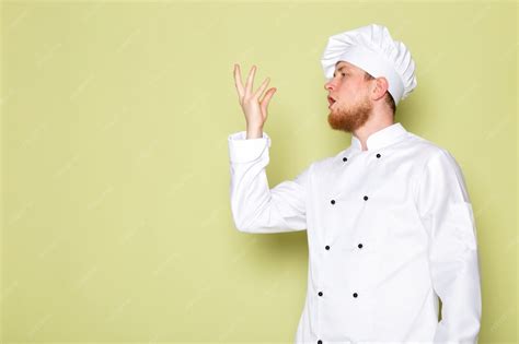 A front view young male cook in white cook suit white head cap | Free Photo
