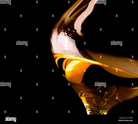snifter of brandy in elegant glass with space for text on black ...