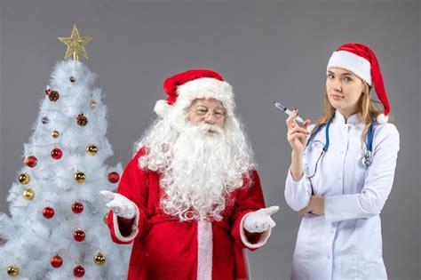 Front view of santa claus with female doctor who's holding injection on ...