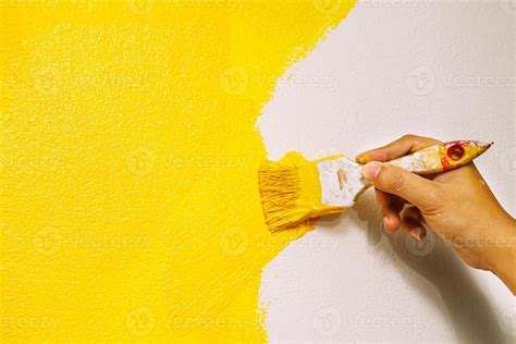 Paint brush, close up hand painter worker painting on surface wall ...