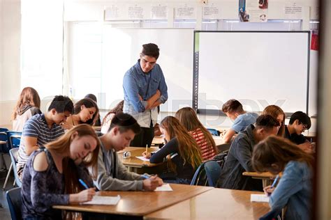 Male High School Teacher Standing By Interactive Whiteboard Teaching ...