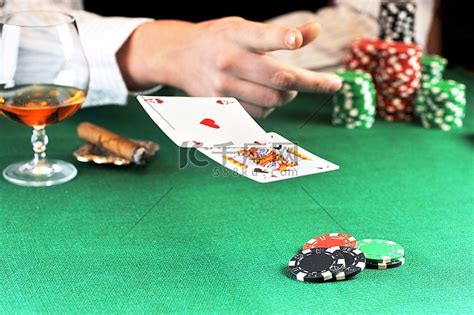 男人坐在赌桌旁打牌高清摄影大图-千库网