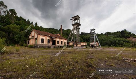 Empty yard with old abandoned buildings and mine mechanisms locating ...