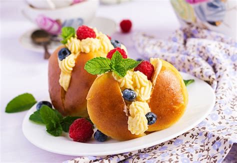 Rum savarian buns decorated with whipped cream and fresh berries | Free ...