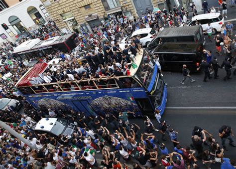 Fans celebrate as Italy's players react on the bus during the victory ...