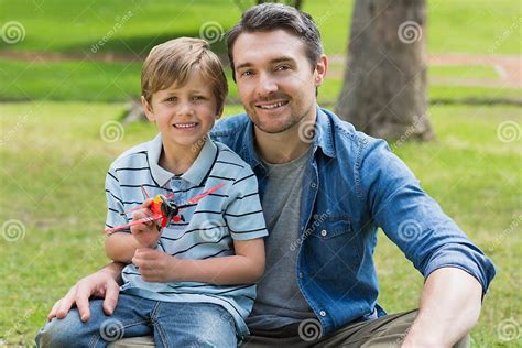 Boy with Toy Aeroplane Sitting on Father S Lap at Park Stock Photo ...