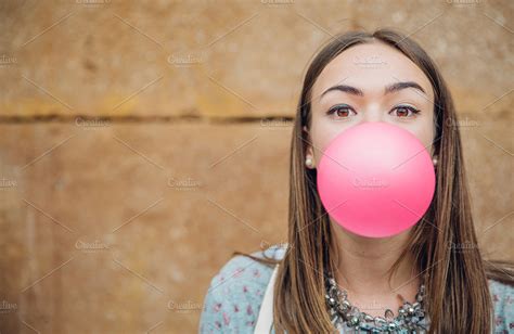 Young girl blowing pink bubble gum | High-Quality People Images ...