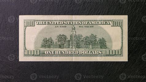One hundred dollar bill on a black plate Back view Financial concept ...