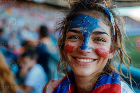 A joyful French woman with his face painted in the blue white and red ...