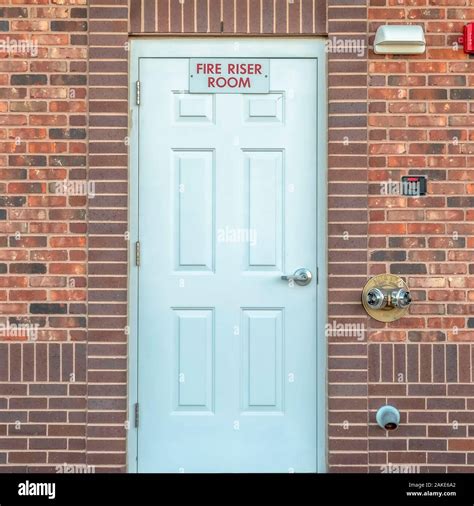 Square Fire Riser Room sign on the white wood door of a building with ...